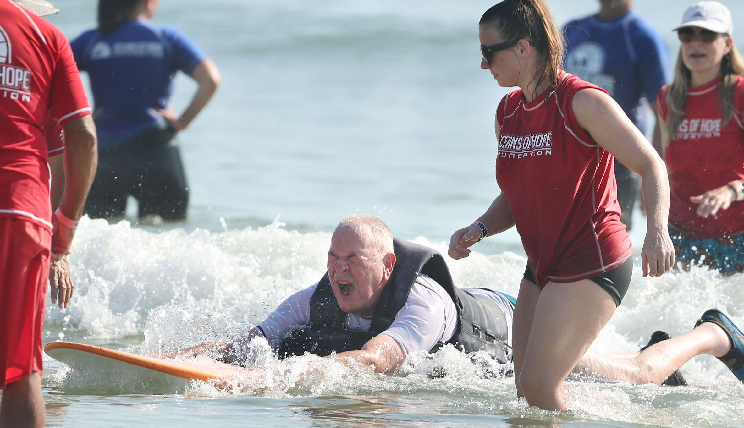 Navy veteran Rick Rettinger enjoys his ride on a surfboard...
