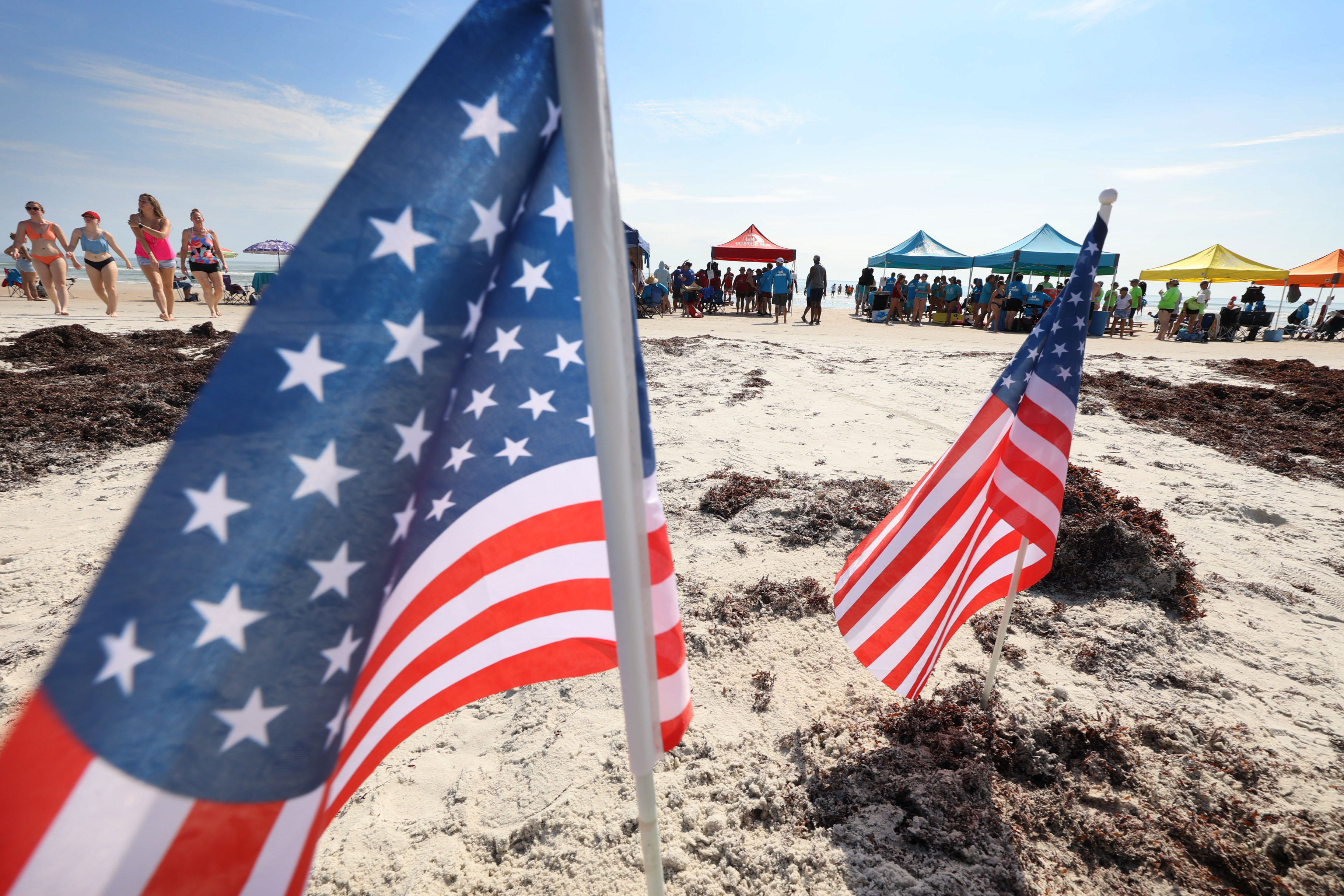 Tents and American flags are set up in the sand...