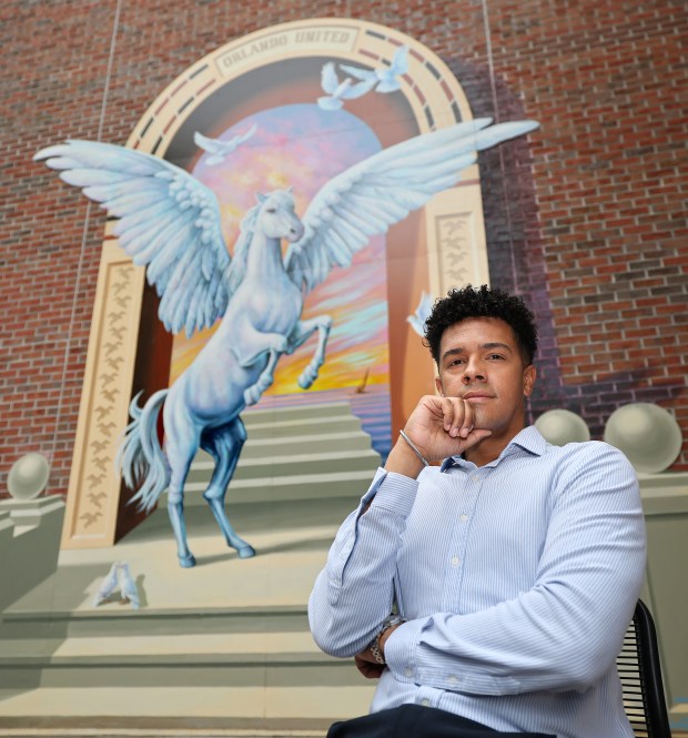 Pulse survivor Brandon Wolf in front of the restored tribute mural at the University of Central Florida Student Union, Monday, June 1, 2026. Wolf is a nationally-recognized civil rights and gun safety advocate whose two best friends were among the 49 killed in the nightclub massacre in 2016. (Joe Burbank/Orlando Sentinel)