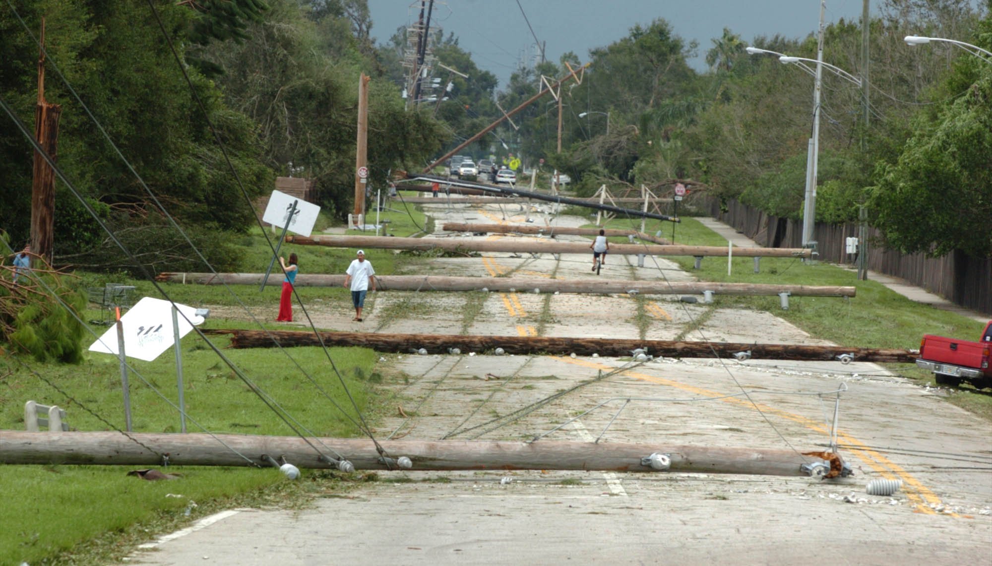 Utility poles blown over by Hurricane Charley lie across Lake...