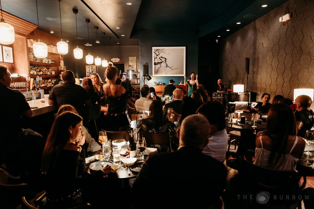 Photo of a group of people at a venue in Miami watching live music. 