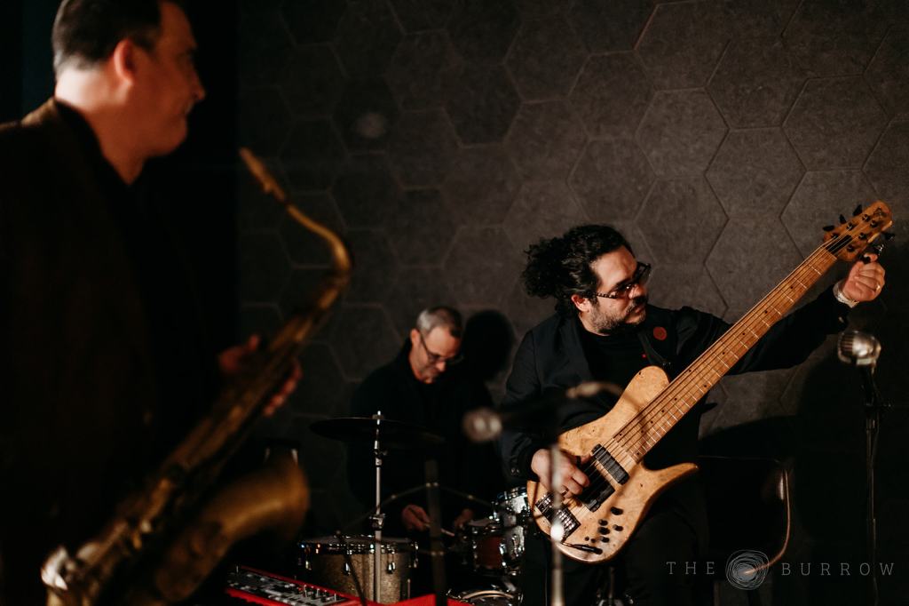 A man playing bass at a venue in Miami. 