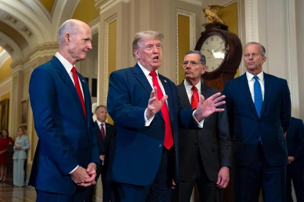 President Donald Trump, joined from left by Sen. Rick Scott, R-Fla., Sen. John Barrasso, R-Wyo., and Senate Majority Leader John Thune, R-S.D., speaks to reporters as he finishes his lunch meeting with Republican senators, at the Capitol in Washington, Wednesday, June 24, 2026. (AP Photo/J. Scott Applewhite)