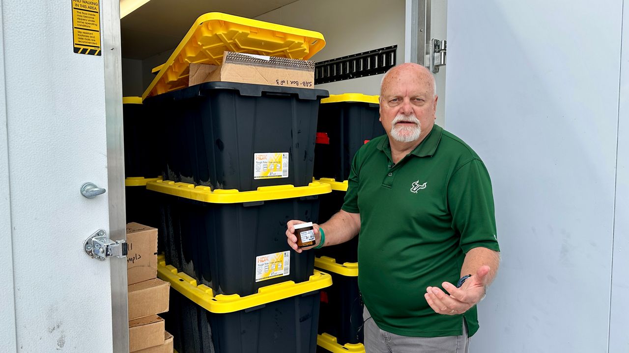USF College of Marine Science Biological Oceanography Professor Steve Murawski shows a frozen fish sample from a bin that was recovered and has been secured in a portable trailer freezer on campus. (Spectrum News/Josh Rojas)