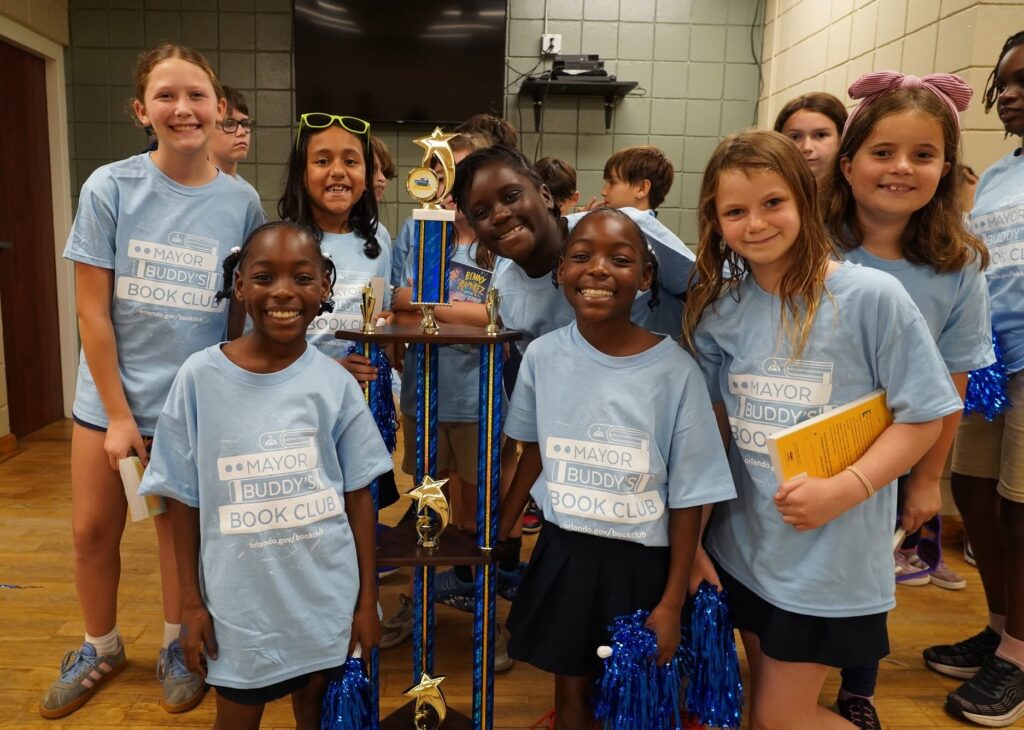 a group of smiling students holding a trophy