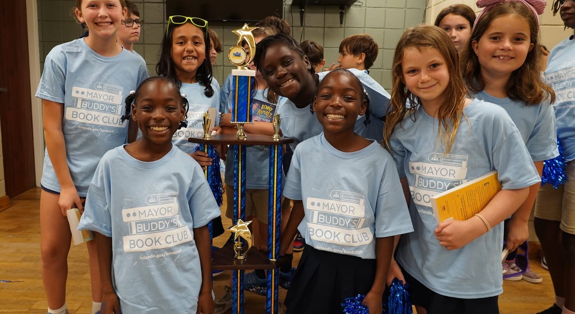 a group of smiling students holding a trophy