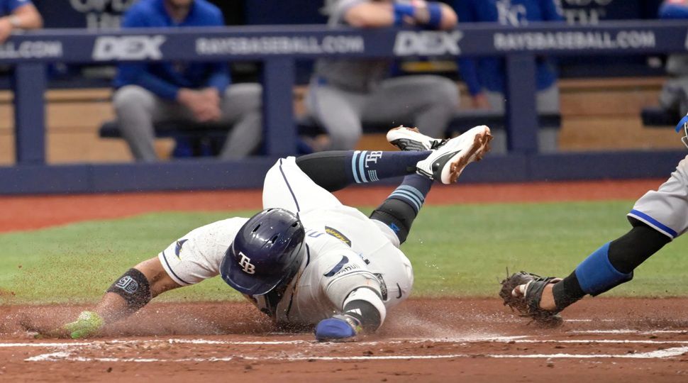 Tampa Bay Rays Yandy Díaz scores before the tag from Kansas City Royals catcher Salvador Perez during the first inning of a baseball game Tuesday, June 23, 2026, in St. Petersburg, Fla. (AP Photo/Jason Behnken)