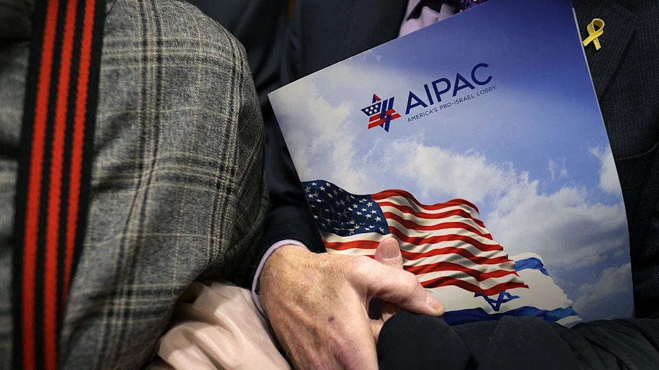 A visitor holding an AIPAC folder inside an elevator at Rayburn House Office Building.