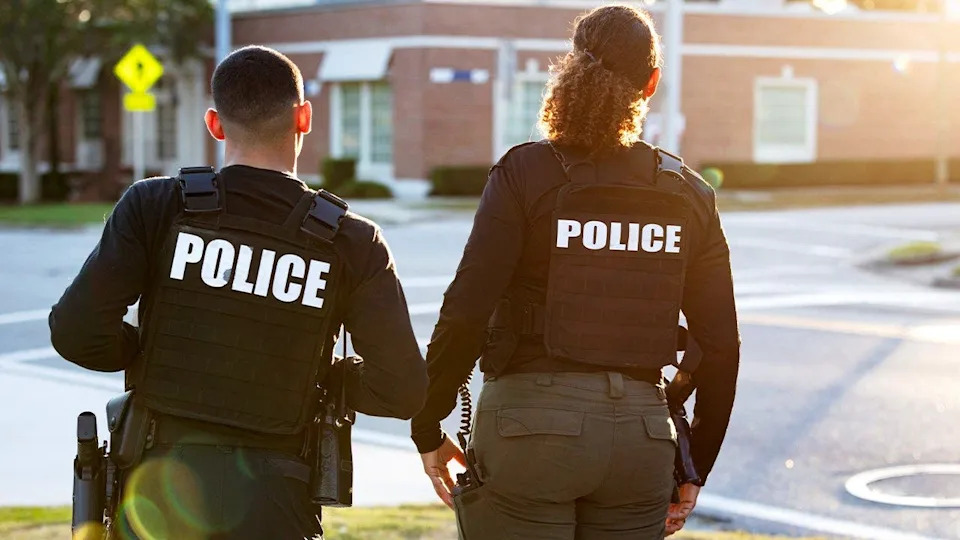 Two police officers patrol neighborhood on foot during community policing effort.