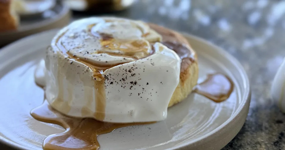 A thick, fluffy Japanese soufflé pancake topped with crème fraîche icing, vanilla bean shavings, and maple syrup.