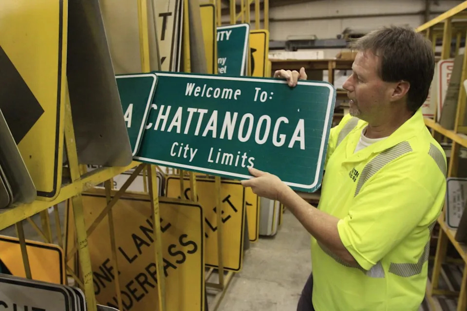 In this file photo taken October 25, 2011, Pete Woodard shows off new Chattanooga city limits signs at the City of Chattanooga Traffic Operations building in Chattanooga, Tennessee. (AP Photo/Chattanooga Times Free Press, Dan Henry)