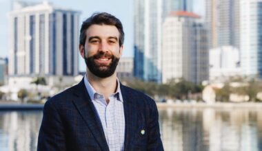 Mack Feldman, principal at Feldman Equities, stands along Tampa’s Riverwalk with the downtown skyline in the background.