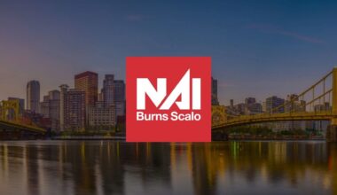 NAI Burns Scalo logo displayed over the Pittsburgh skyline and yellow suspension bridges along a riverfront.