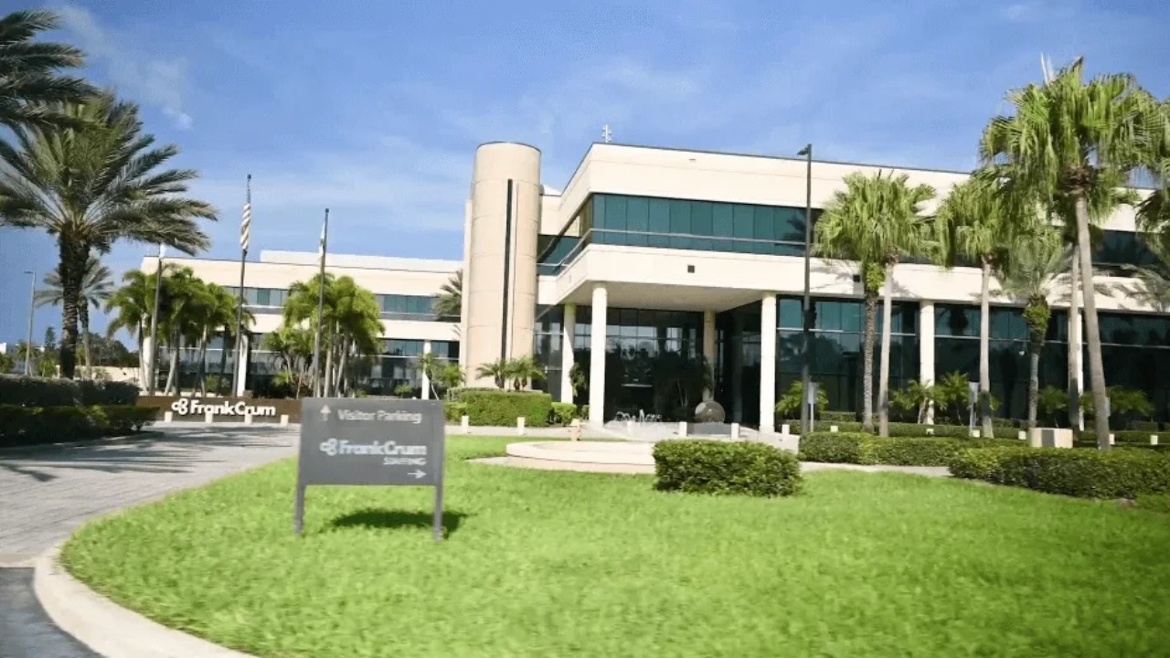 FrankCrum headquarters in Clearwater, Florida, featuring a two-story office building surrounded by palm trees and landscaped grounds.