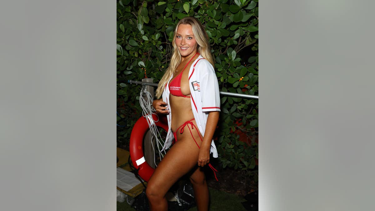 Camille Kostek walking on the red carpet at Sports Illustrated Swimsuit Runway Show in Miami Beach