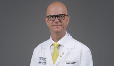 Christopher Senkowski, M.D. professional headshot in FIU/Baptist Health branded white coat.