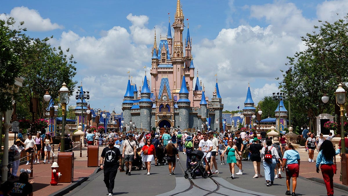 People walking past Cinderella's Castle at Magic Kingdom Park in Orlando, Florida
