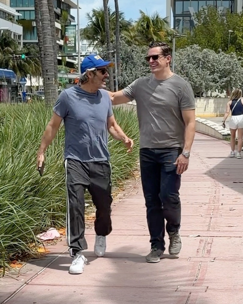 Andy Cohen and Kevin Sobieski walking and smiling during a Miami getaway.