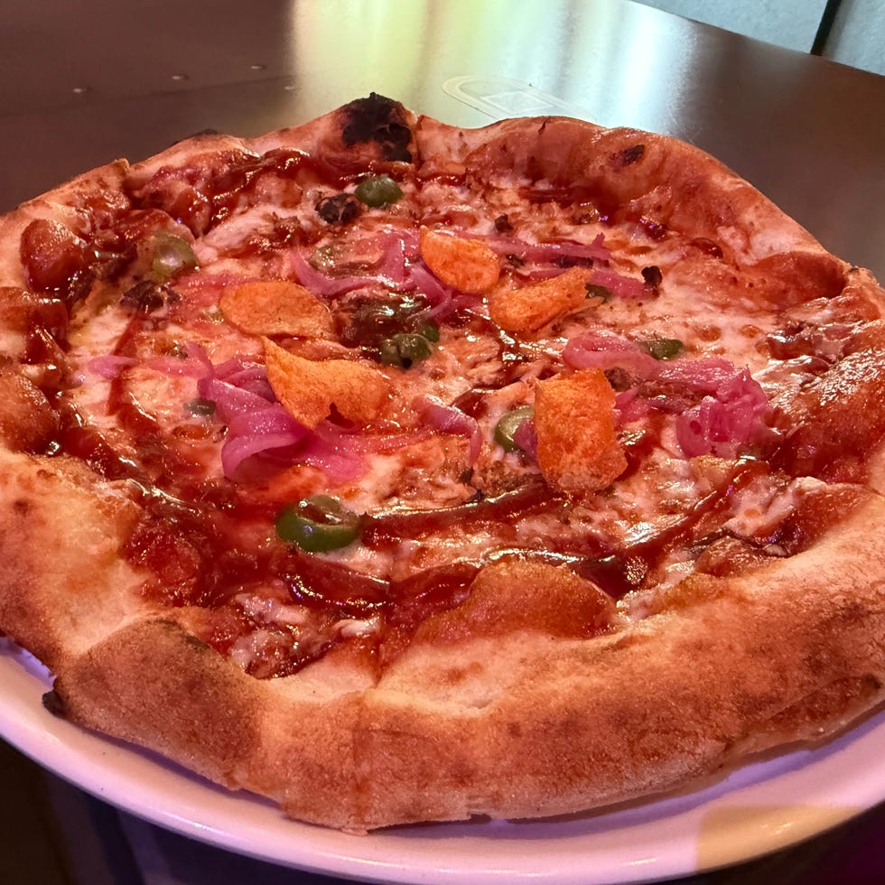 Pepperoni pizza with red onions, jalapeños, and barbecue sauce on a white plate. Pepperoni pizza with red onions, jalapeños, and barbecue sauce on a white plate.