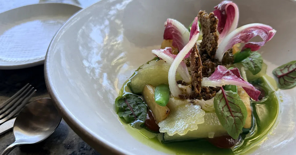 A gourmet starter dish featuring compressed Fuji apples, creamy burrata cheese, and a prosecco crumble topping.