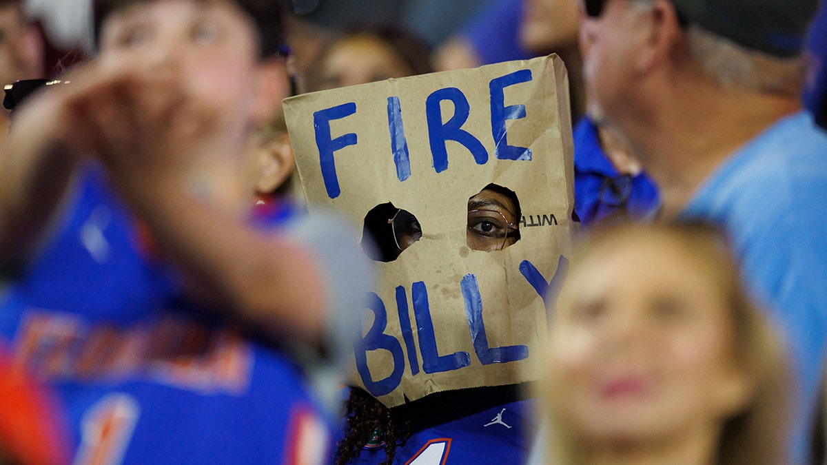 A fan wearing a Fire Billy Napier paper bag over their head at Ben Hill Griffin Stadium