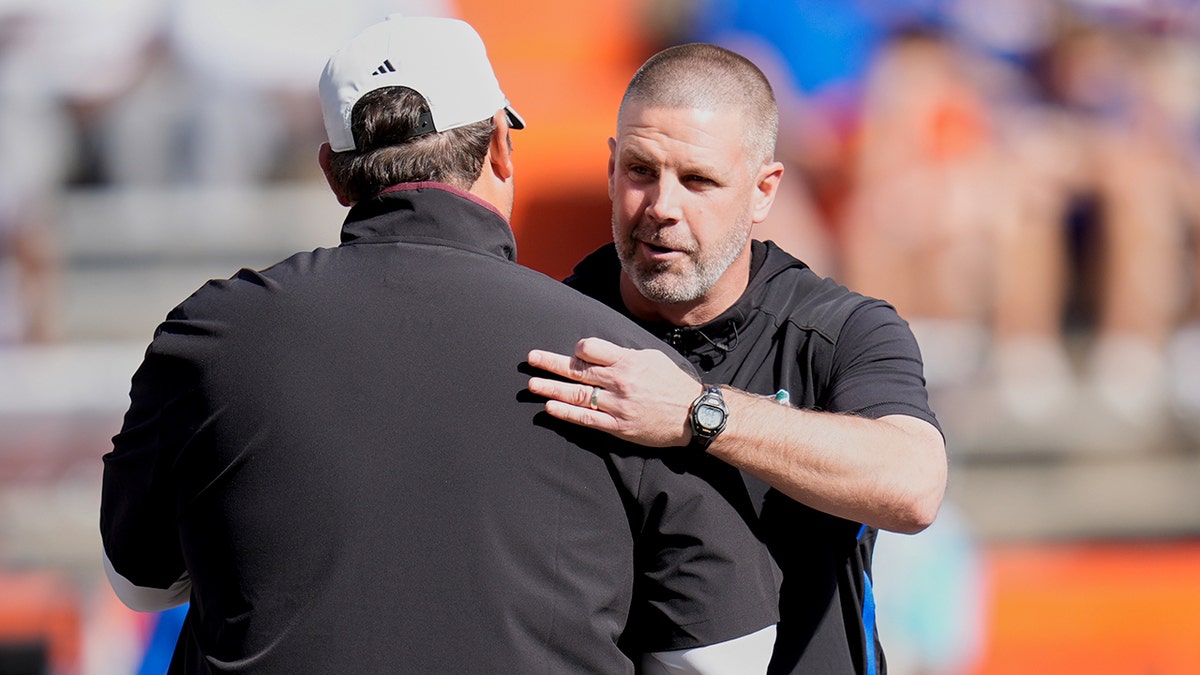 Mississippi State head coach Jeff Lebby and Florida head coach Billy Napier greeting each other on football field