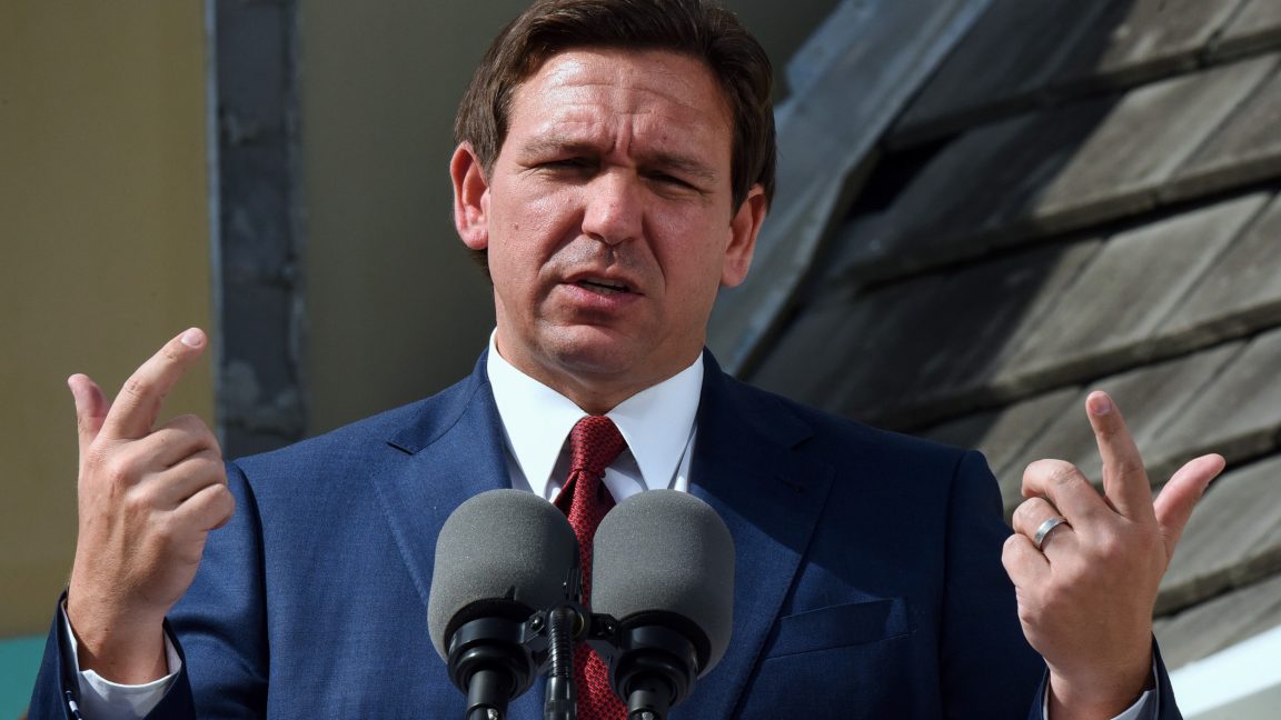 Florida Gov. Ron DeSantis speaks at a press conference while gesturing with his hands.