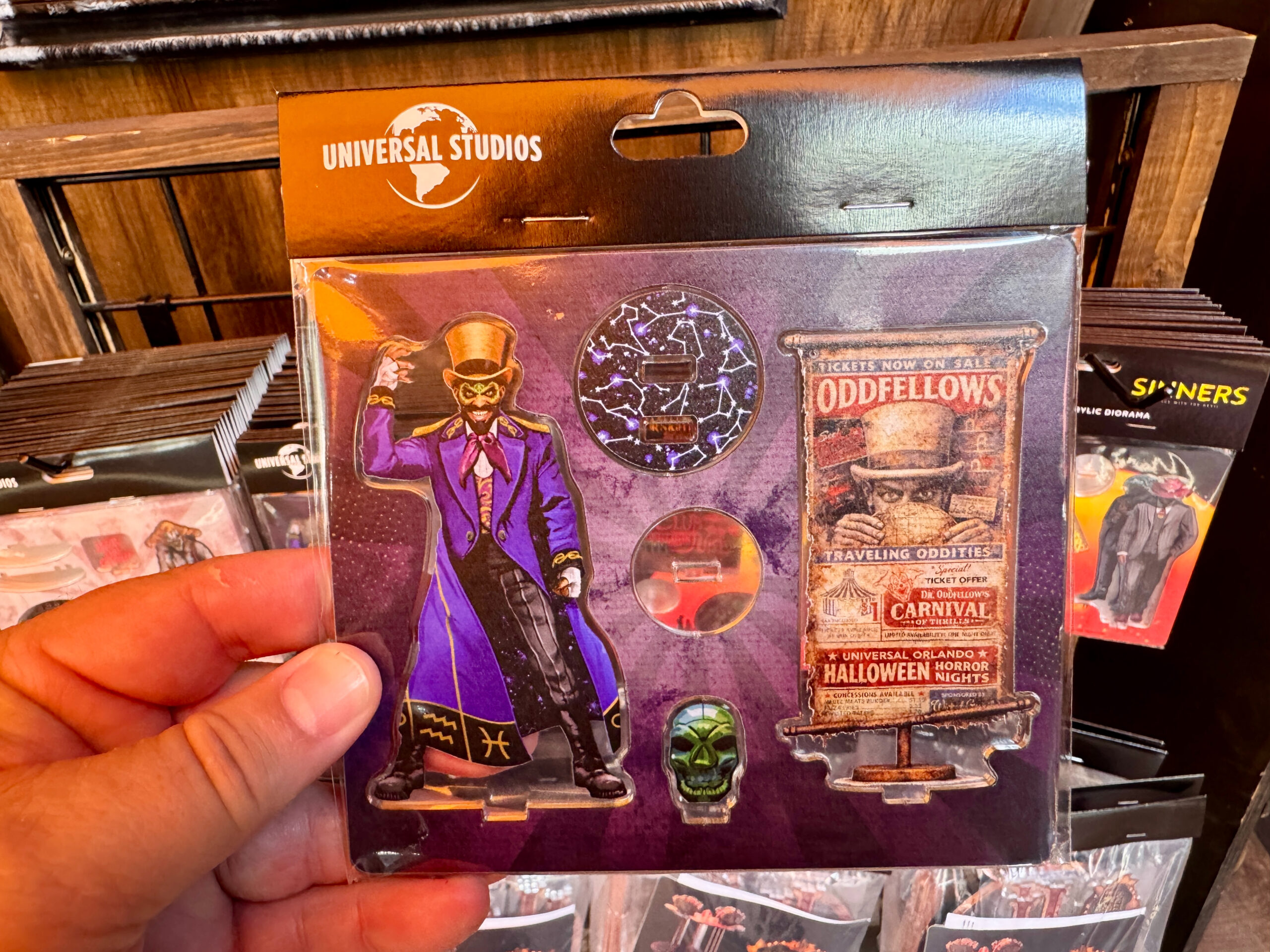 Similarly, this Dr. Oddfellow acrylic figure shows the character, a sign for his traveling oddities show, a green skull, and a base showing constellations.