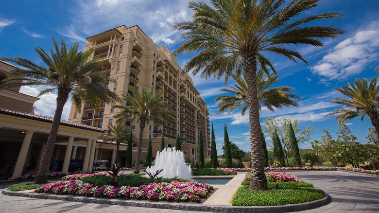 Exterior of Four Seasons Resort at Disney World in Lake Buena Vista with palm trees, flowers, and a water fountain