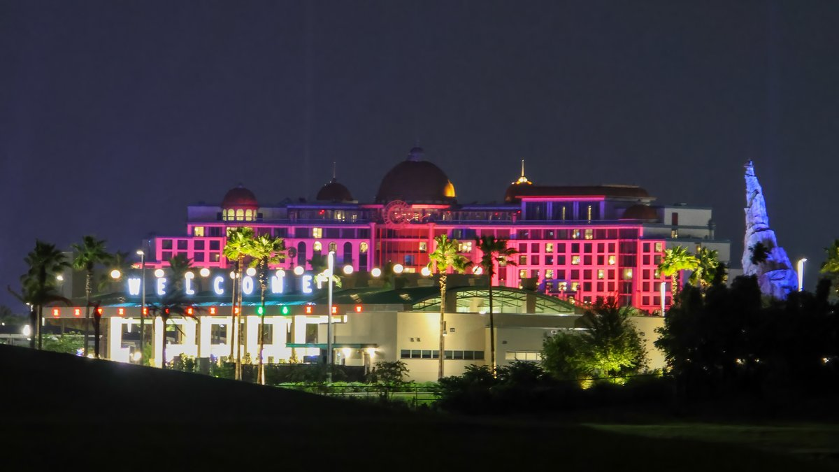 The pink and purple lights against the Helios Grand Hotel changed in waves across the walls. As if it were being reflected through water, it ripples across the side of the hotel.