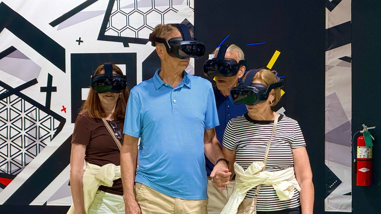 Guests hold on tightly, as this VR experience takes reality to a new dimension. (Spectrum News/Allison Walker)
