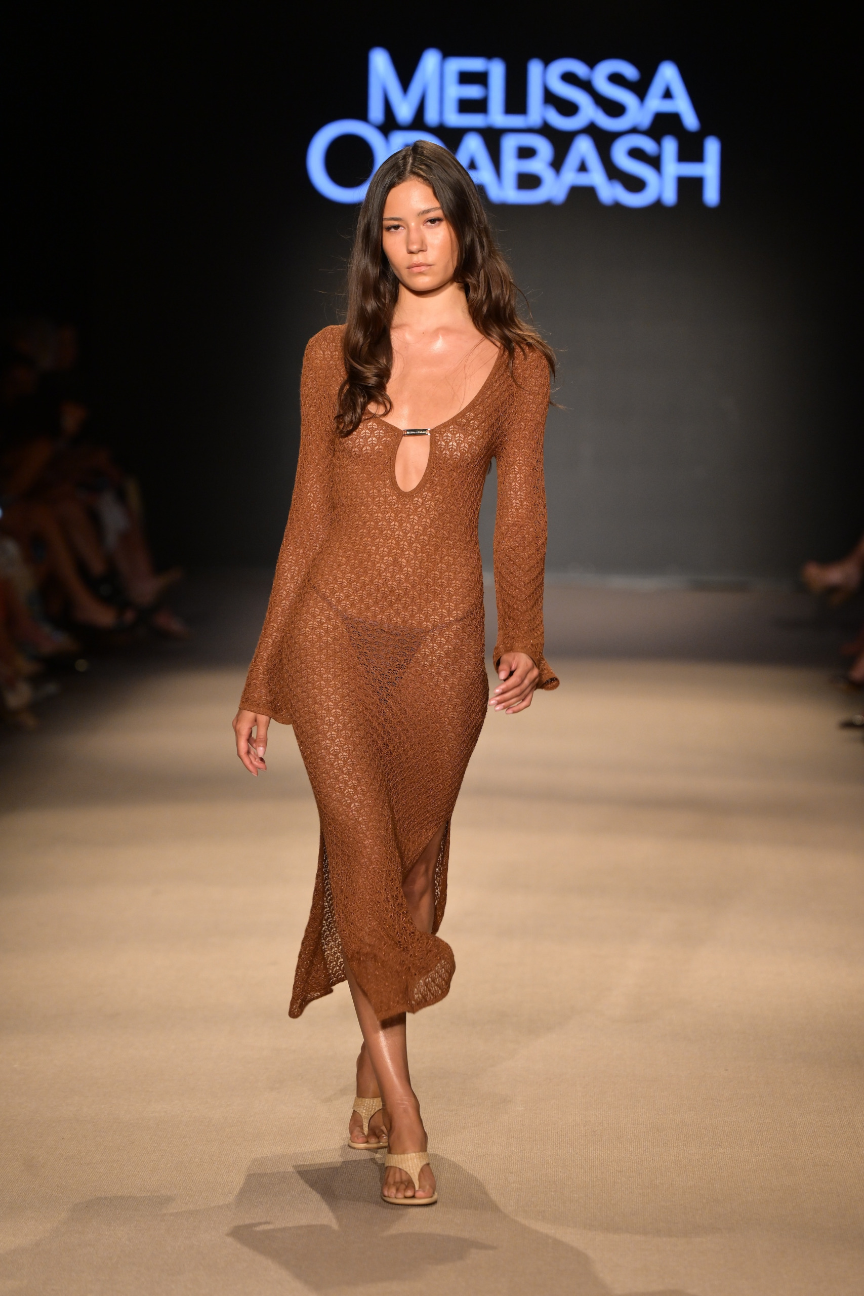 A model walks in Melissa Odabash's show wearing a brown crochet cover up