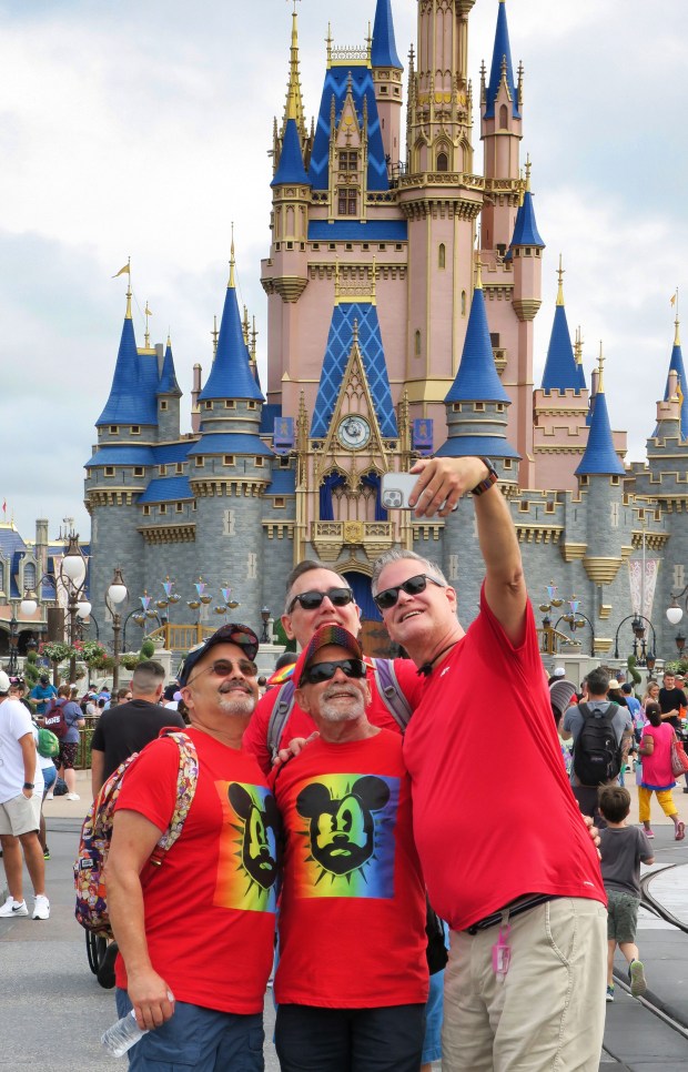 Guests visiting from St. Petersburg wear red shirts while shooting a selfie at Cinderella Castle at the Magic Kingdom at Walt Disney World, in Lake Buena Vista, Fla., Saturday, June 3, 2023. Although not sanctioned by Disney as an official park event, the wearing of red shirts at the Magic Kingdom on the first Saturday in June is a guests-generated tradition dating back to 1991 to show support for the LGBTQ community during national Pride month. (Joe Burbank/Orlando Sentinel)