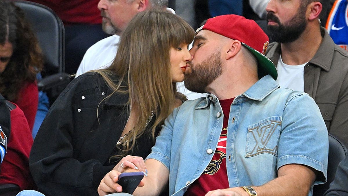 Singer Taylor Swift and Travis Kelce kissing at Rocket Arena in Cleveland Ohio