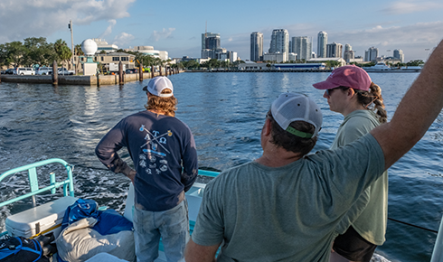 As the boat exists Bayboro Harbor, the crew looks back at the damaged Marine Science Laboratory. 