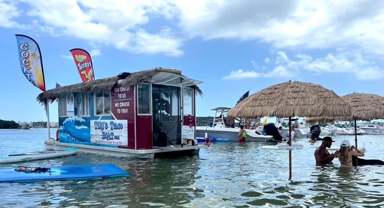 Tiki's Taco Boat featuring a thatched palm leaf roof and matching umbrellas in the water nearby