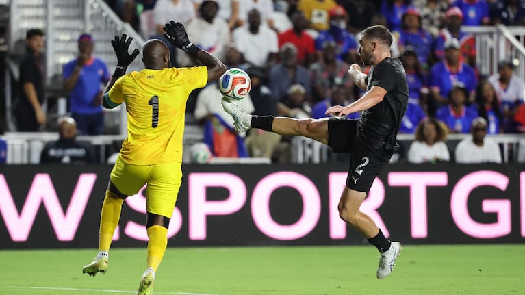 Tim Payne challenges the Haiti goalkeeper in their World Cup warm-up match in Florida.