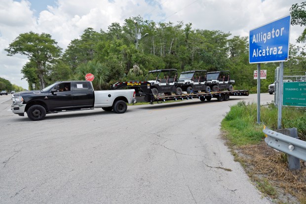 A truck towing golf carts exits "Alligator Alcatraz" at Dade-Collier Training and Transition Airport on the Big Cypress National Preserve in Ochopee, Fla., on Wednesday, June 24, 2026. State officials informed vendors in a call Monday morning that they could begin "demobilizing," or taking down, the tents, fences, trailers and other structures at the detention center, according to three people familiar with the call. (Amy Beth Bennett / South Florida Sun Sentinel)