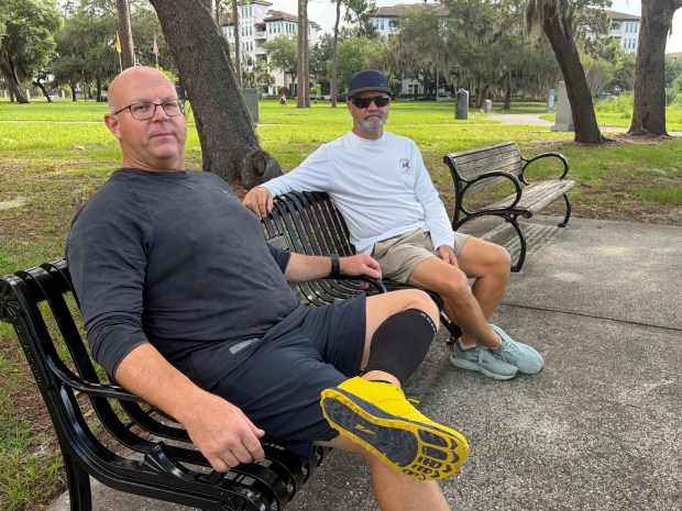 Retired firefighters Chris DeMaagd (left) and Joseph McCluan sit on the bench in Orlando Veterans' Memorial Park where they will meet any first responder struggling with anything from daily life to PTSD or who just wants to talk. (Scott Maxwell/Orlando Sentinel)