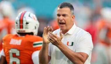 Oct 17, 2025; Miami Gardens, Florida, USA; Miami Hurricanes head coach Mario Cristobal works with his players before the game against the Louisville Cardinals at Hard Rock Stadium. Mandatory Credit: Sam Navarro-Imagn Images