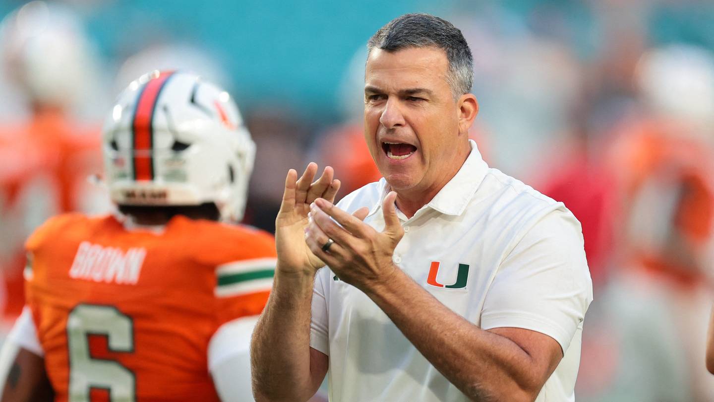 Oct 17, 2025; Miami Gardens, Florida, USA; Miami Hurricanes head coach Mario Cristobal works with his players before the game against the Louisville Cardinals at Hard Rock Stadium. Mandatory Credit: Sam Navarro-Imagn Images
