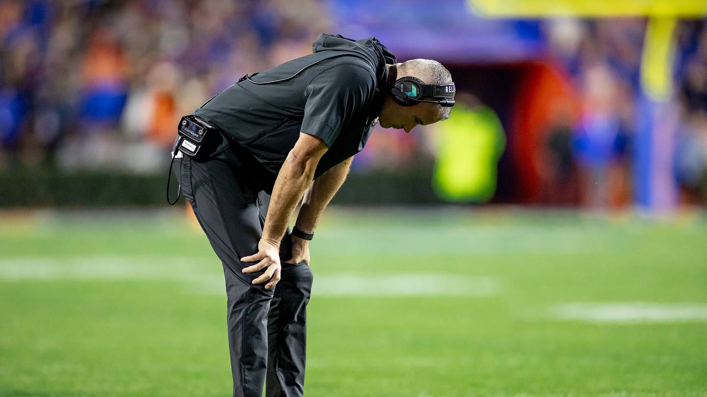 Florida State Seminoles head coach Mike Norvell holds his head between his legs during the second half against the Florida Gators at Steve Spurrier Field at Ben Hill Griffin Stadium in Gainesville, FL on Saturday, November 25, 2023. [Matt Pendleton/Gainesville Sun]