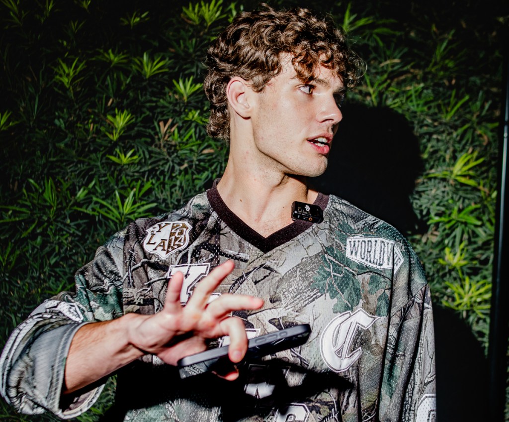A young man puts his hand in front of a camera