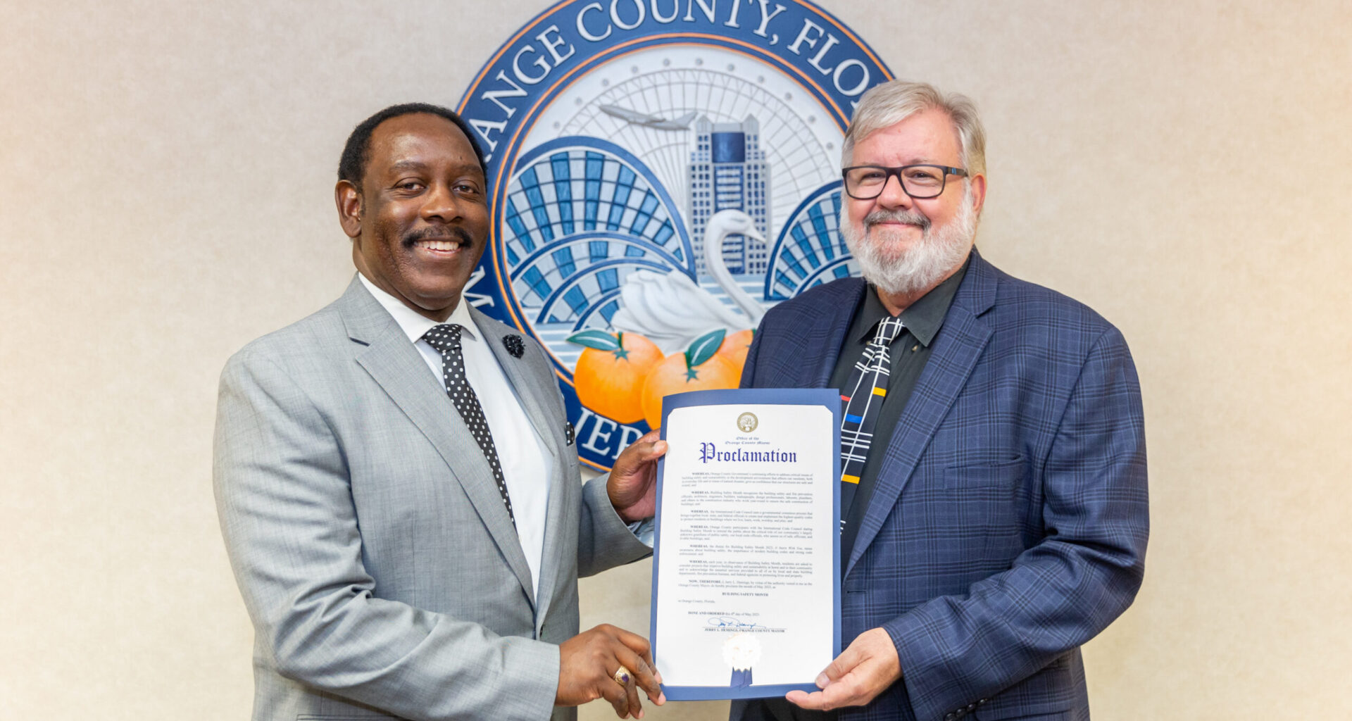 Two men in suits holding a proclamation