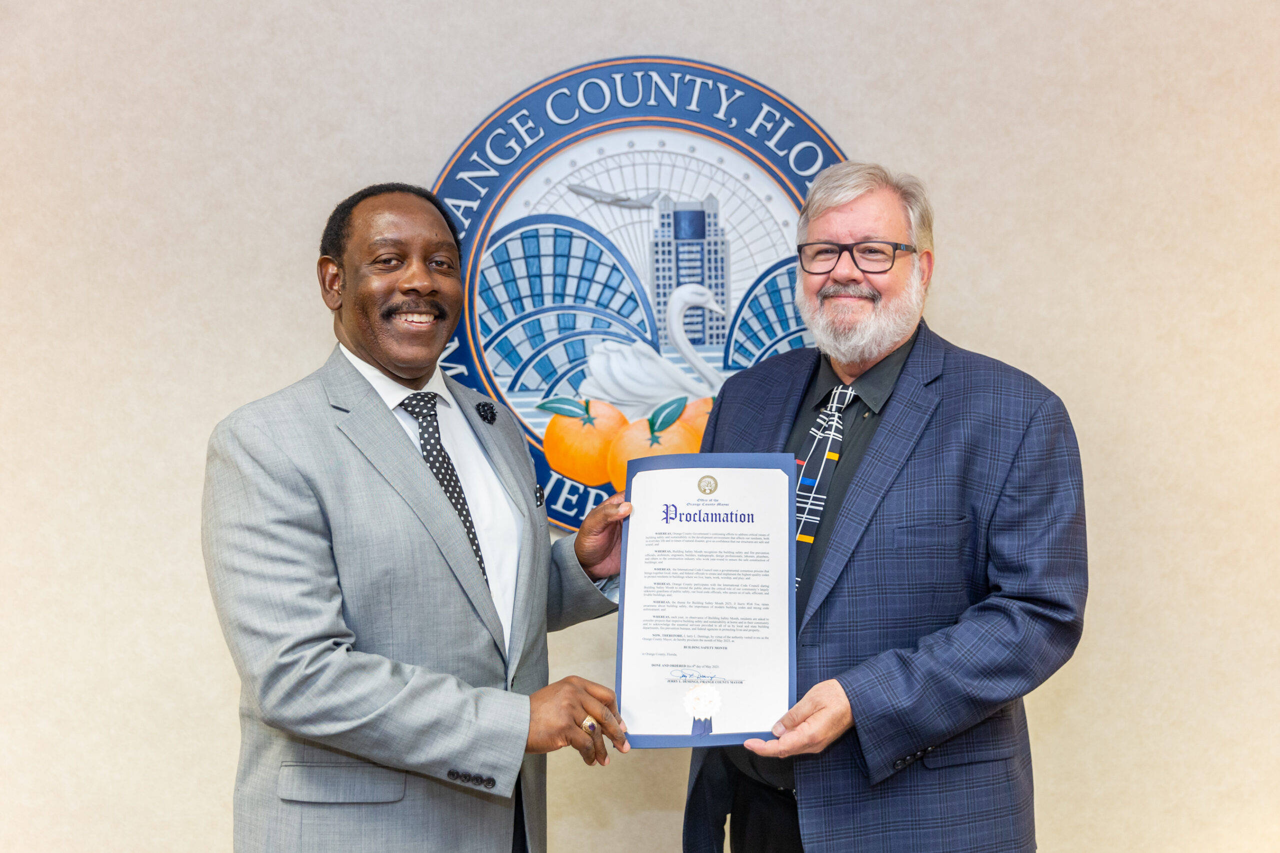 Two men in suits holding a proclamation