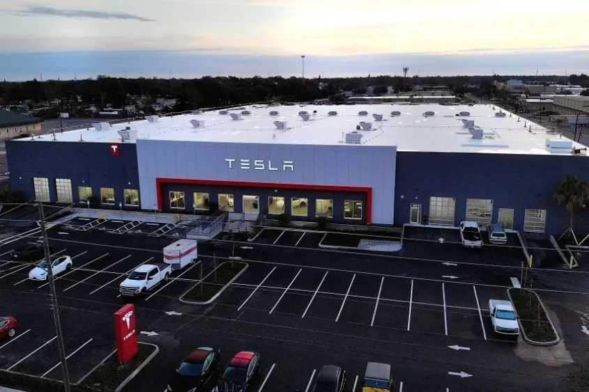 Tesla's sales and service center in Lealman, Florida, with a large showroom and service building viewed from above.