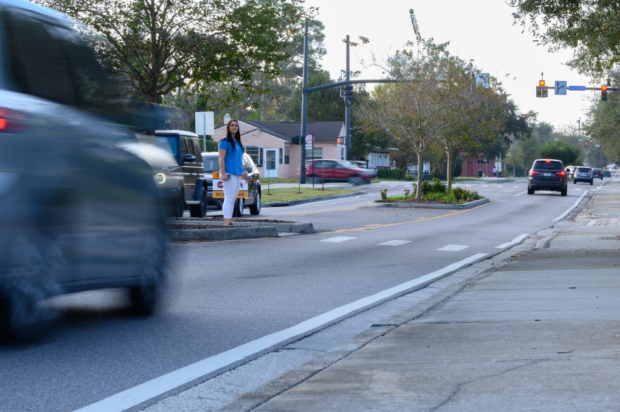 Cars drive along a road in Winter Park as someone waits to cross during a “Best Foot Forward” operation in 2023.
