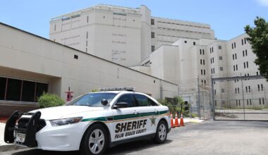 A photo shows a car with the label "Palm Beach County Sheriff" parked in front of a gray building.