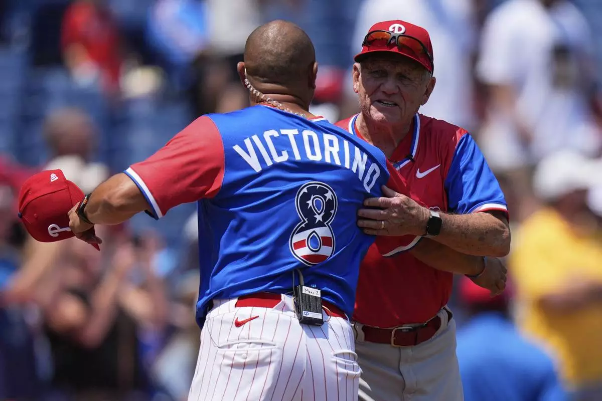 Shane Victorino, left, coach of the National League embraces Larry Bowa, coach of the American League, ahead of the MLB All-Star Futures baseball game Sunday, July 12, 2026, in Philadelphia. (AP Photo/Chris Szagola)