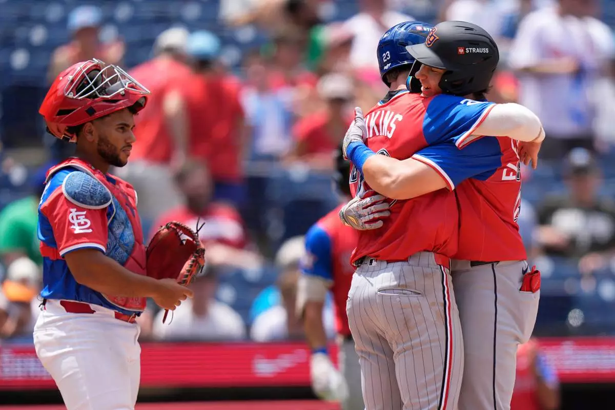American League's Nathan Flewelling, right, embraces American League's Walker Jenkins after Flewelling hit a two-run home run as National League's Rainiel Rodriguez looks on in the sixth inning of the MLB All-Star Futures baseball game Sunday, July 12, 2026, in Philadelphia. (AP Photo/Chris Szagola)